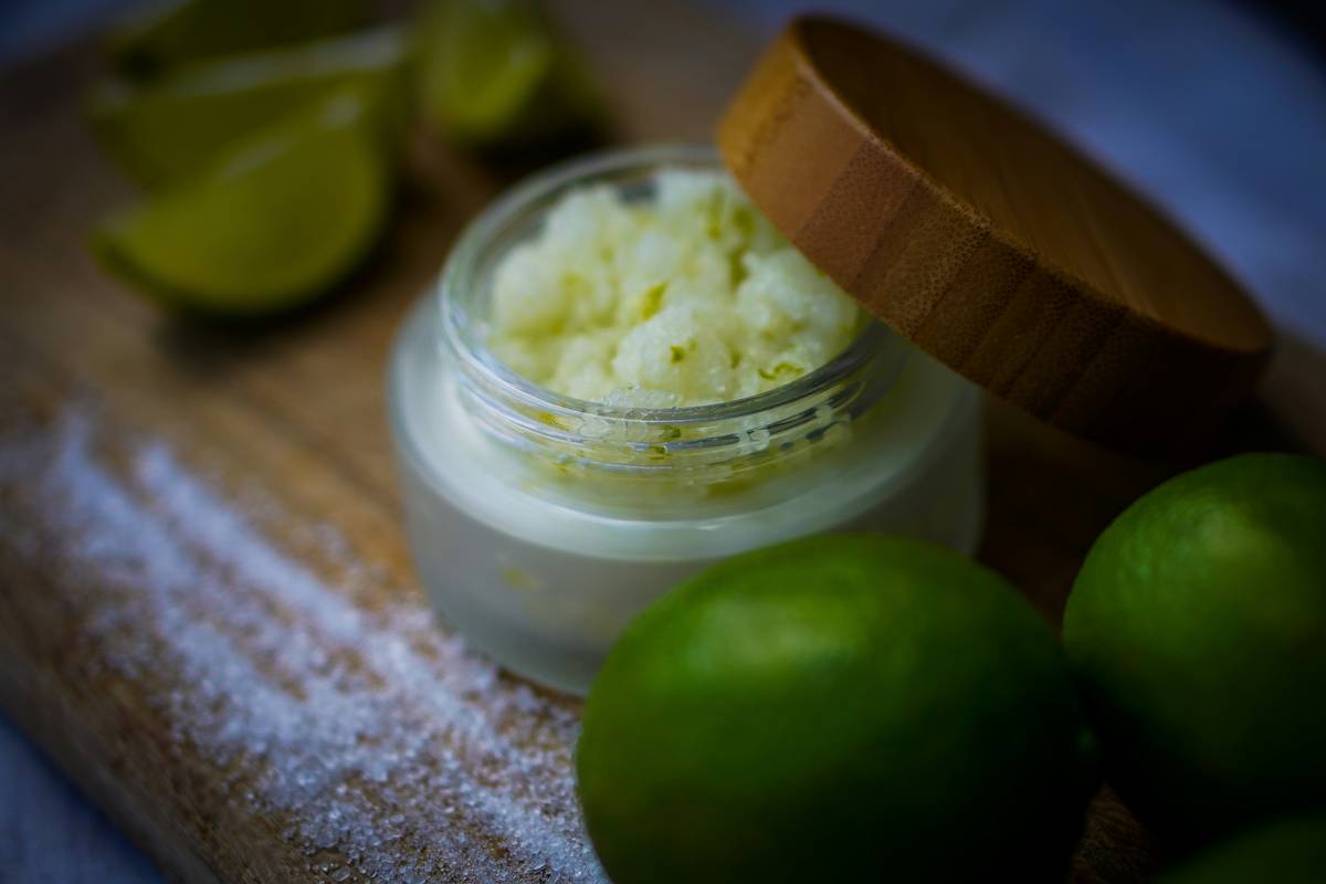 making your own body scrub with sugar, coconut oil, and essential oils in a mason jar